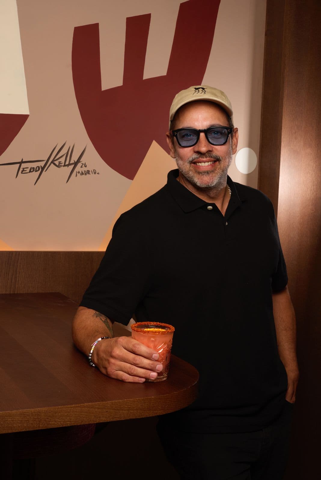 Teddy Kelly sonríe junto a su firma en el mural de 5 Gallos