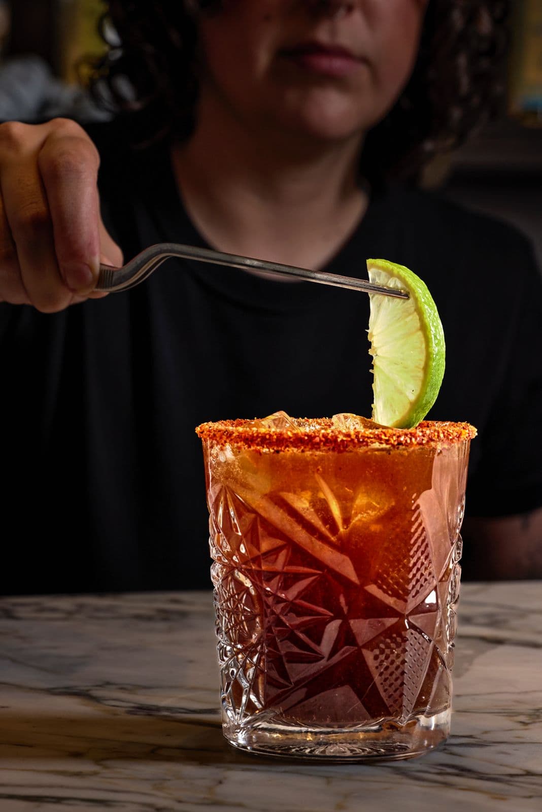 Michelada with a chile rim and a lime wedge
