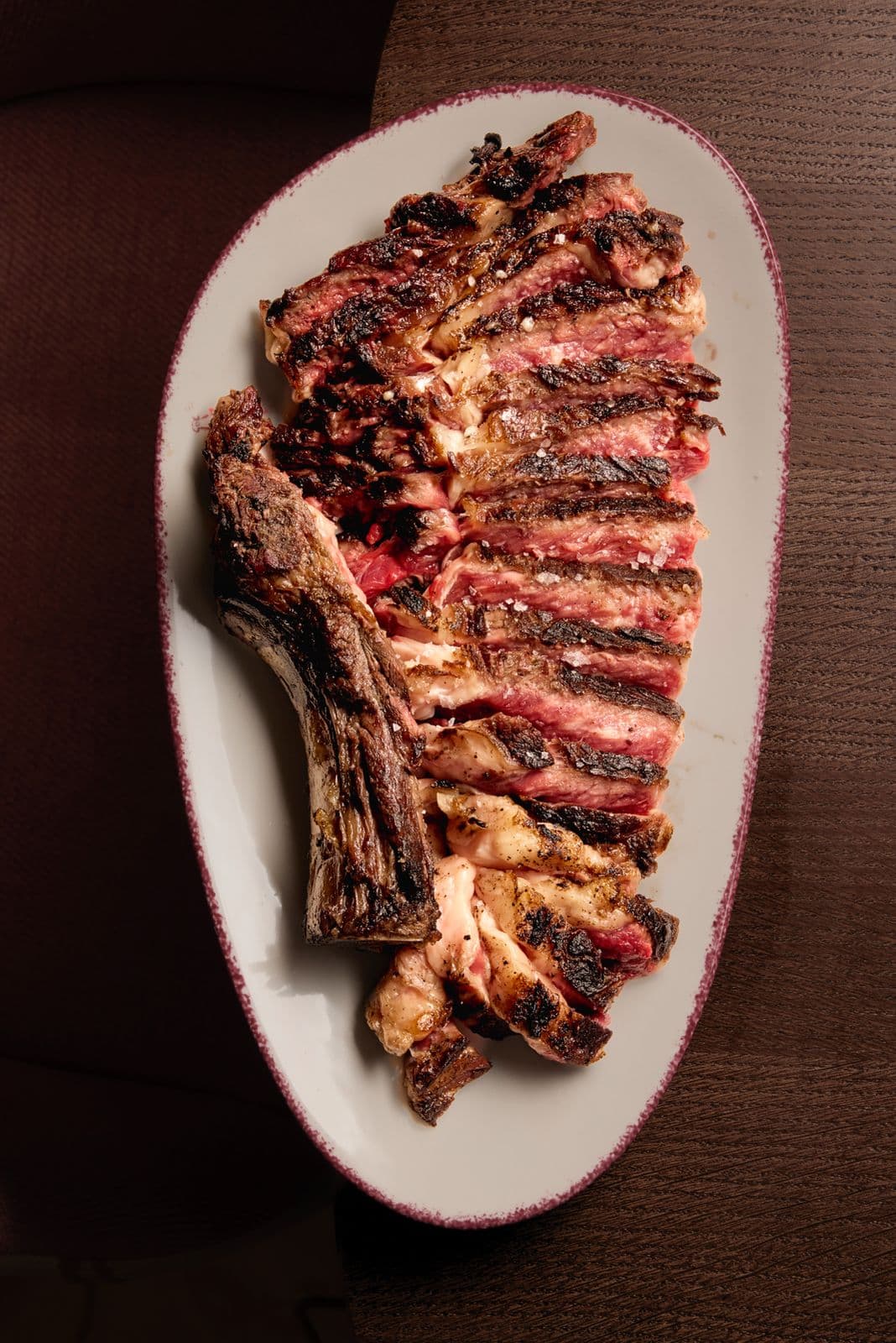 Grilled vaca vieja txuleta, sliced into strips on an oval platter