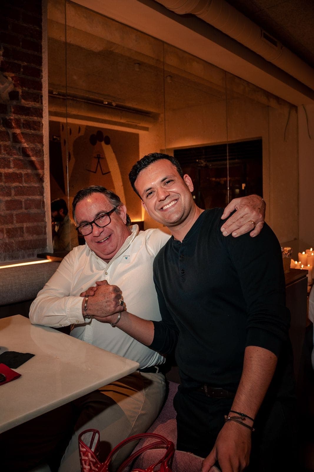 Two diners hugging and smiling at a table in the dining room