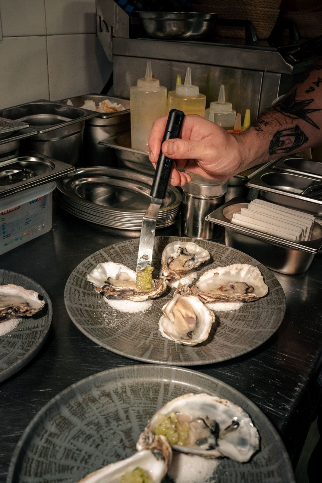 En la cocina, terminando una ronda de ostras con la picada