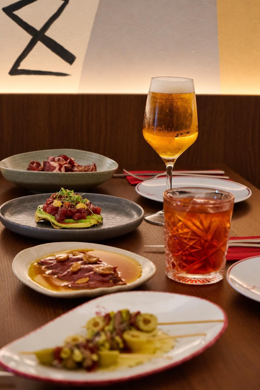 Sharing plates — jamón, tuna on avocado and gildas — with a draft beer and a cocktail